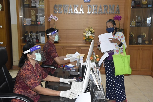 Pastikan Pelayanan Tetap Berjalan Ditengah Pandemi, Staf Pelayanan Desa Kesiman Kertalangu Gunakan Face Shield